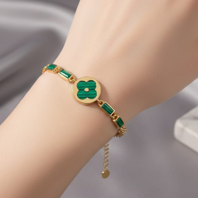 An elegant gold bracelet made of rust-resistant stainless steel, featuring a large, distinctive green flower at its center, adorned with green stones. It has an adjustable clasp for a perfect fit. - Image 2